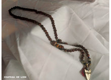 shiva mala necklace with 14k gold arrow pendant made by chateau de lion laying on display cdl-mla-shva-001
