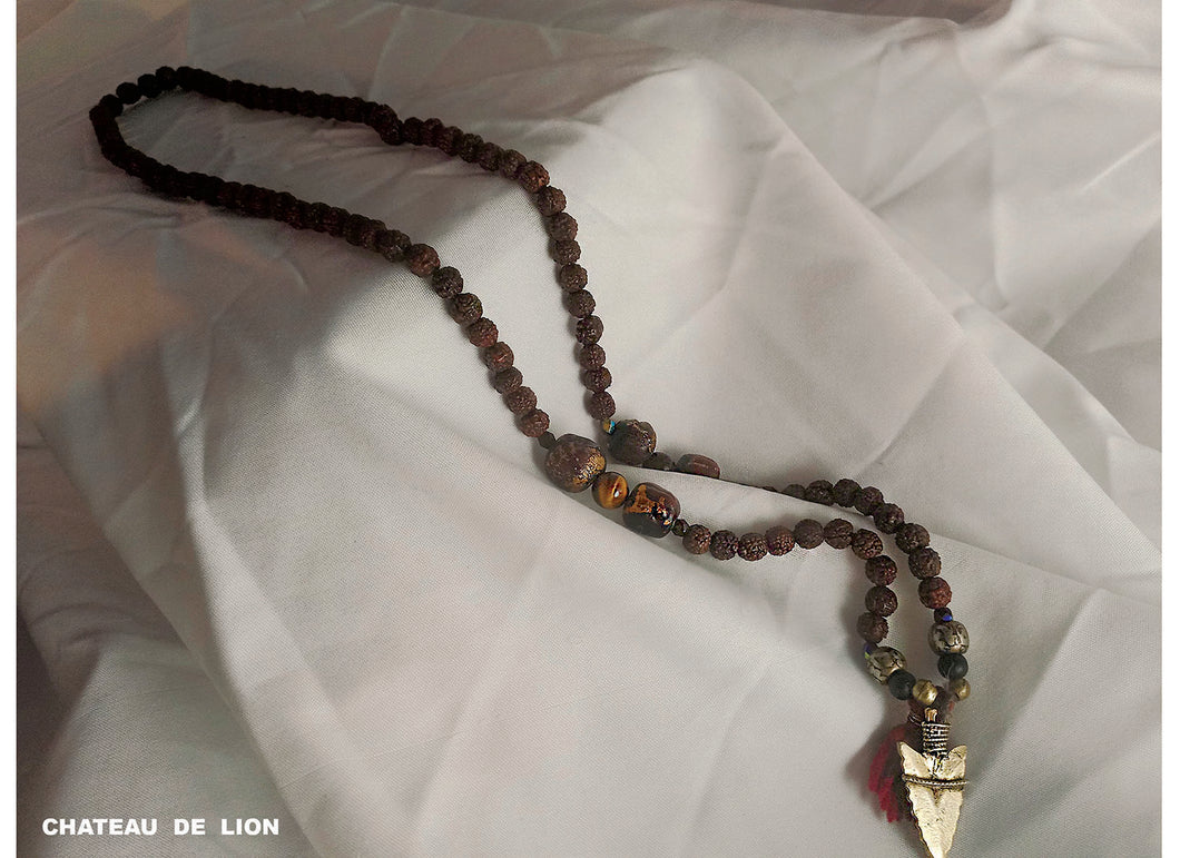 shiva mala necklace with 14k gold arrow pendant made by chateau de lion laying on display cdl-mla-shva-001