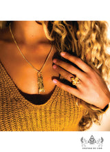 The Fluer De Lis ring in 14k gold made by chateau de lion worn by a model photographed with the egyptian sphinx pendant necklace in 14k gold cdl-rg-flr-gld-01